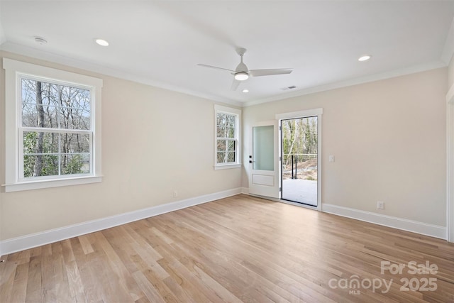 empty room with ornamental molding, recessed lighting, light wood-style flooring, and baseboards