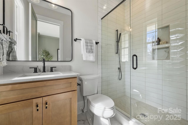 full bathroom with vanity, a shower stall, and toilet