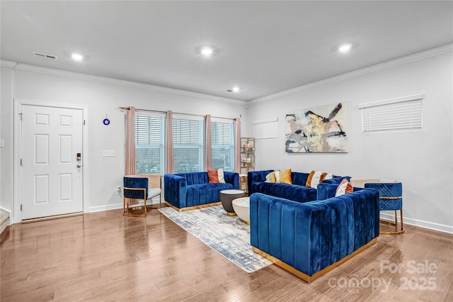 living area with crown molding, baseboards, and wood finished floors