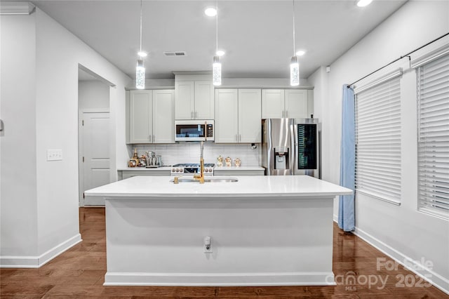 kitchen with a center island with sink, visible vents, stainless steel fridge with ice dispenser, hanging light fixtures, and light countertops