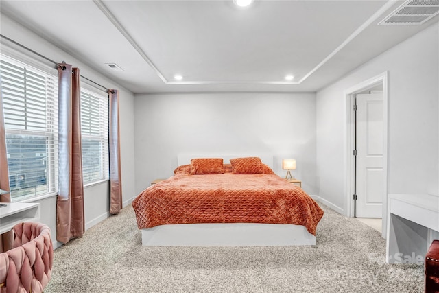 bedroom with baseboards, visible vents, and light colored carpet