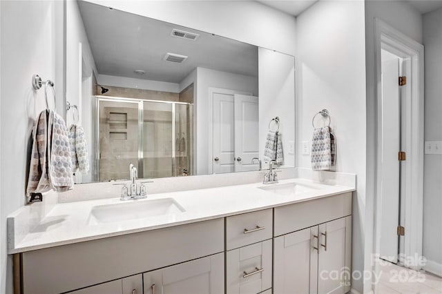 full bath with double vanity, a stall shower, visible vents, and a sink