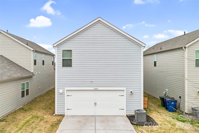 view of side of home featuring a yard, driveway, an attached garage, and central AC unit