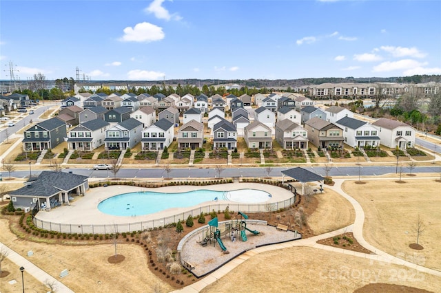 view of pool with a residential view and playground community