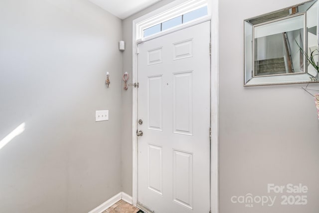 doorway to outside featuring baseboards