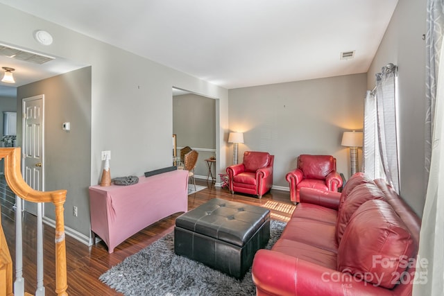 living room featuring dark wood-type flooring, visible vents, and baseboards