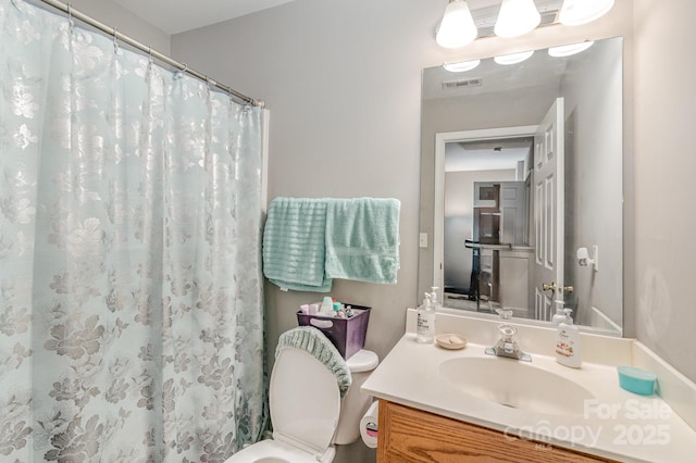 full bath featuring curtained shower, vanity, and visible vents