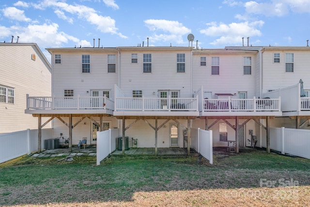 rear view of house featuring a deck, a lawn, cooling unit, and a fenced backyard