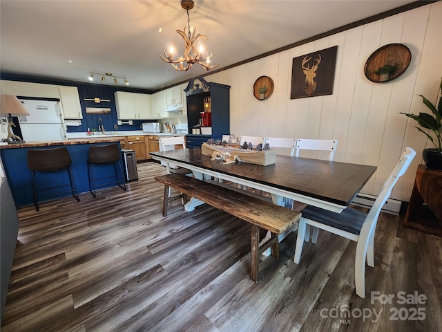 dining room with crown molding, a chandelier, wood-type flooring, and sink