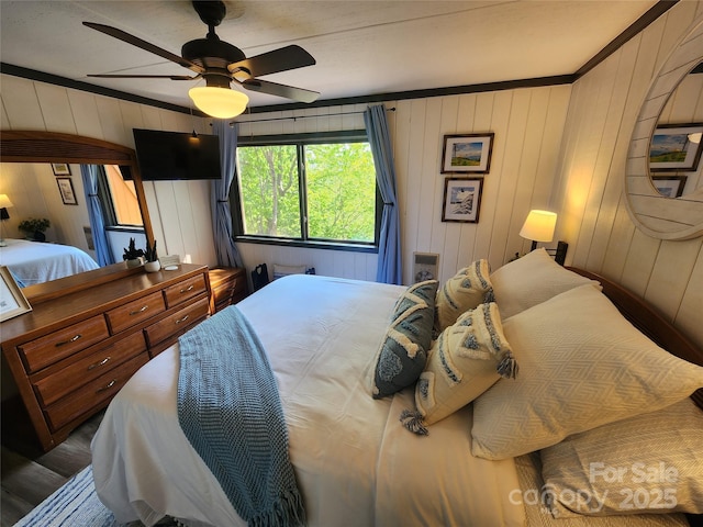 bedroom with crown molding, hardwood / wood-style flooring, and ceiling fan