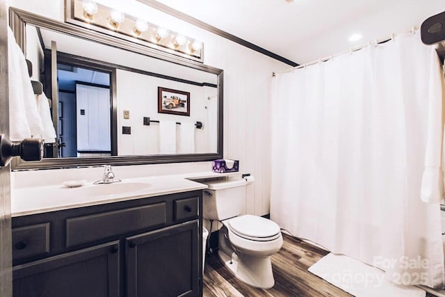 bathroom with toilet, wood-type flooring, vanity, and ornamental molding