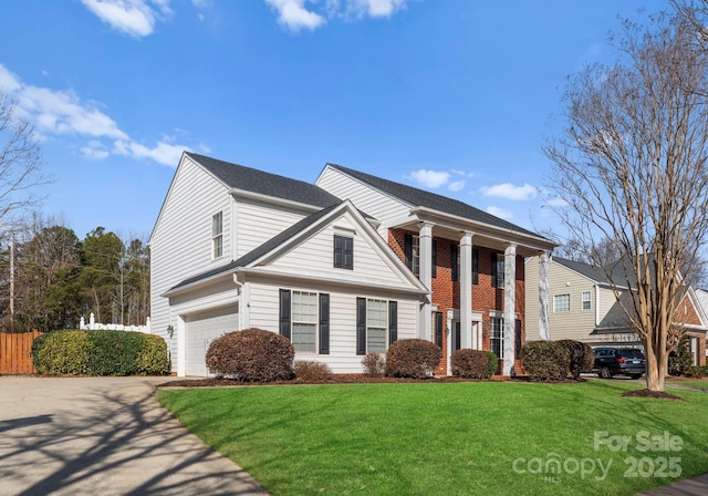 view of front facade with a front lawn, brick siding, driveway, and an attached garage