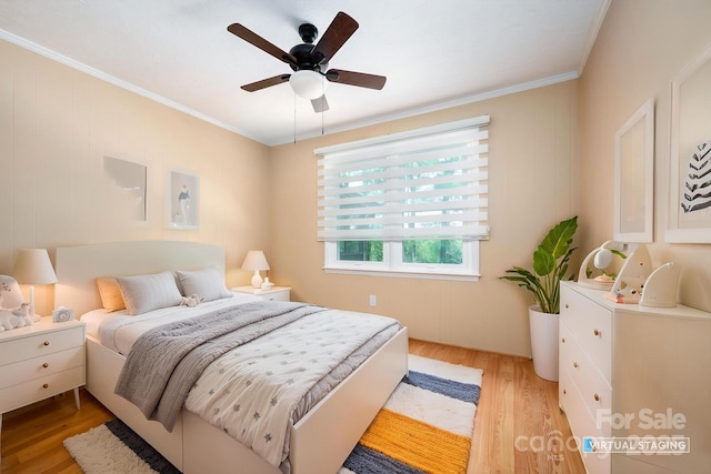 bedroom featuring ornamental molding, a ceiling fan, and light wood-style flooring
