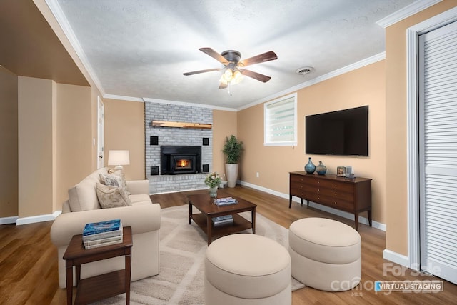 living room with a ceiling fan, visible vents, wood finished floors, and baseboards