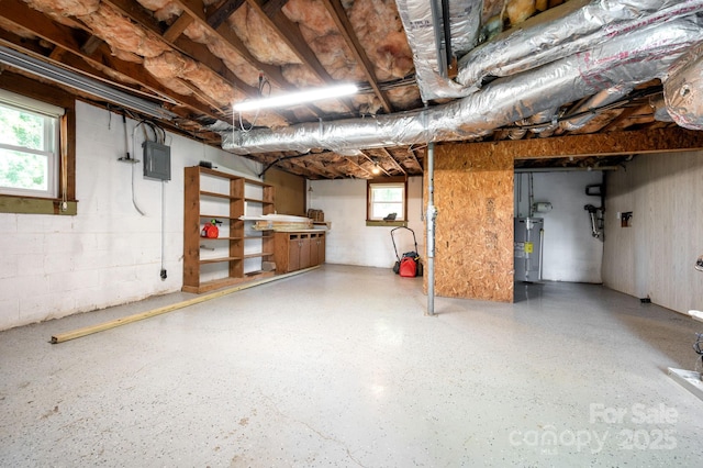 basement featuring plenty of natural light, electric panel, and electric water heater