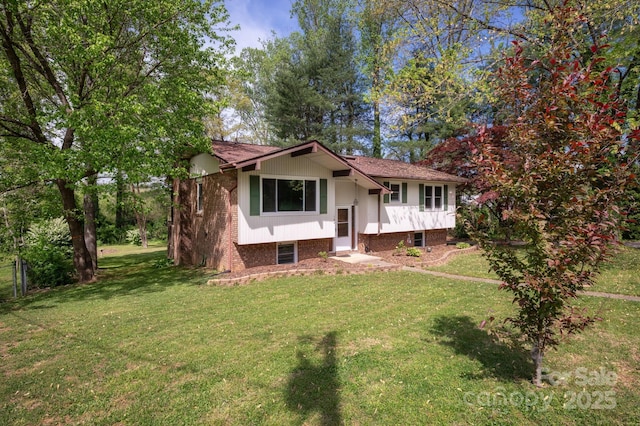 raised ranch with brick siding and a front lawn