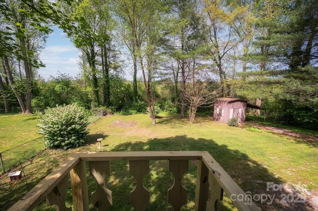 view of yard featuring fence, a shed, and an outbuilding