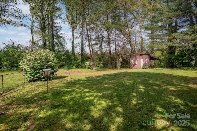 view of yard featuring an outdoor structure, a storage shed, and fence