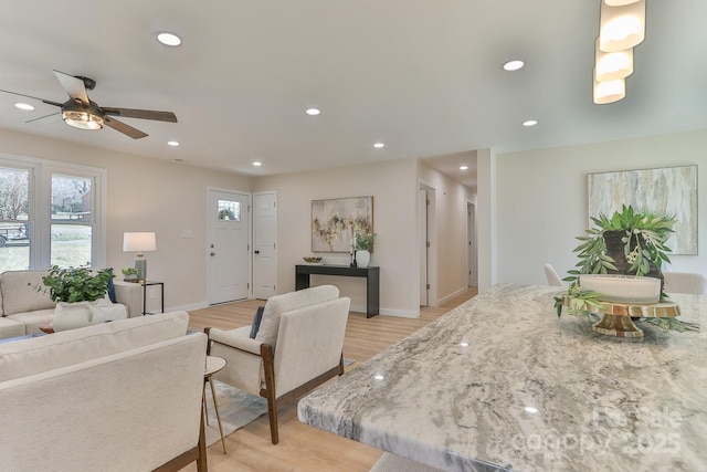 living room with baseboards, plenty of natural light, light wood-style flooring, and recessed lighting