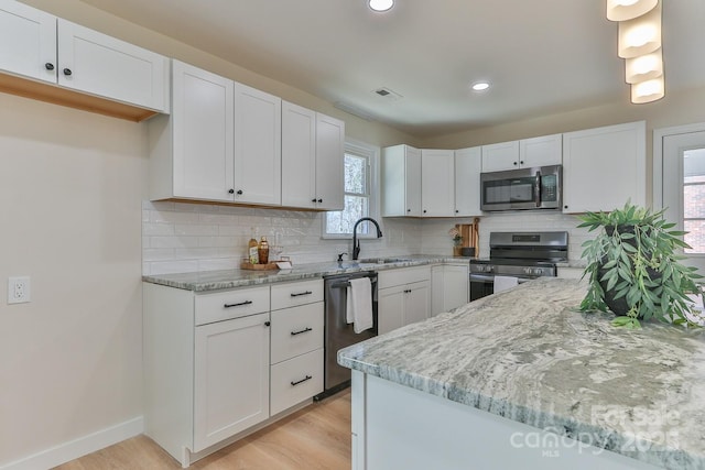 kitchen with stainless steel appliances, white cabinets, and a sink