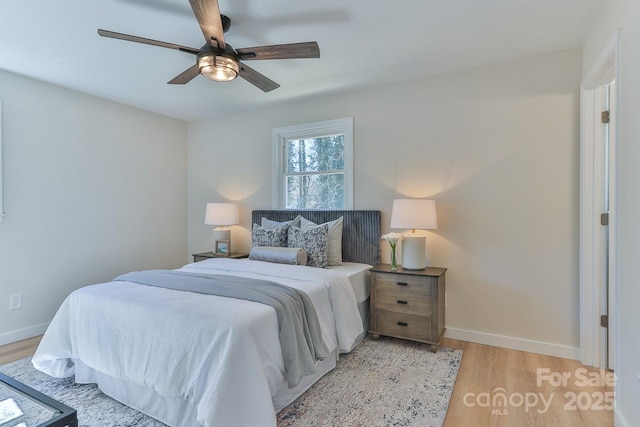 bedroom with a ceiling fan, light wood-style flooring, and baseboards