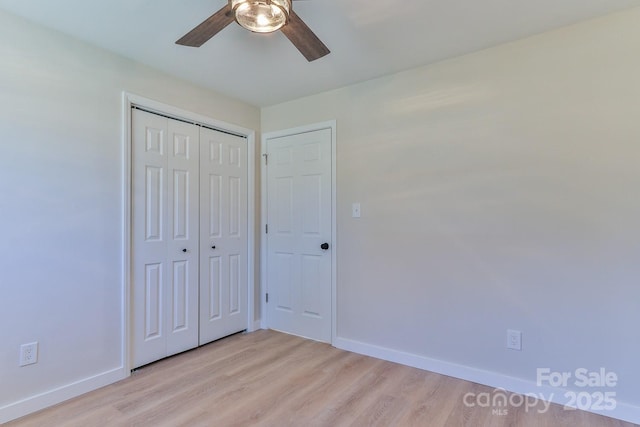 unfurnished bedroom with light wood-style floors, a closet, ceiling fan, and baseboards