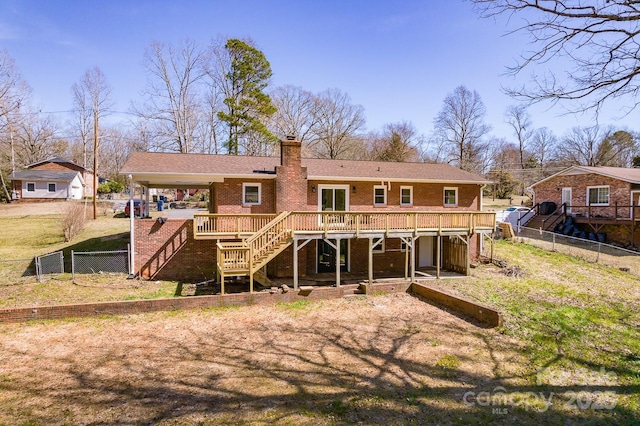 back of house featuring brick siding, a chimney, stairway, a deck, and a fenced backyard