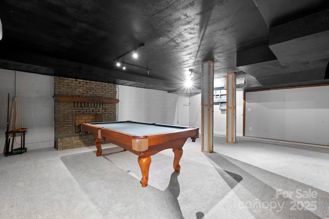 recreation room featuring concrete block wall, light colored carpet, pool table, and a fireplace