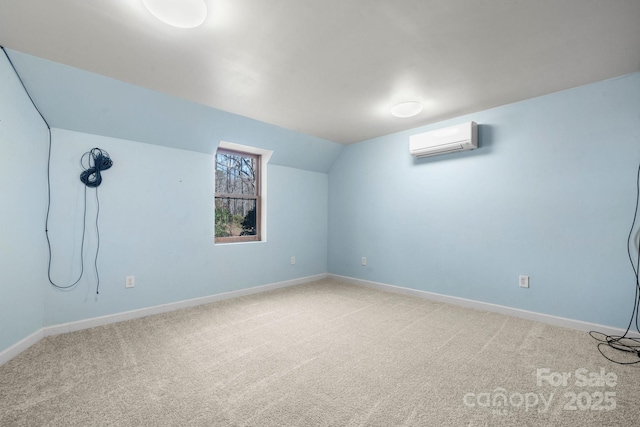 additional living space with carpet floors, baseboards, an AC wall unit, and vaulted ceiling