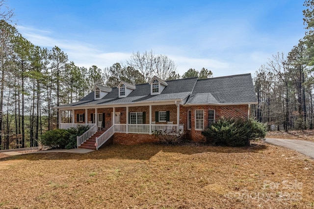 cape cod-style house with a front yard and a porch