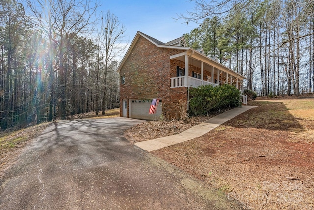 view of side of property featuring a garage and covered porch