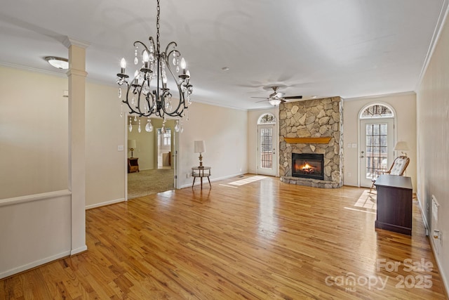 unfurnished living room with ceiling fan, light hardwood / wood-style flooring, a stone fireplace, and ornamental molding