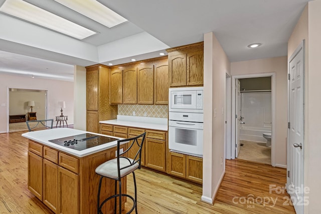 kitchen featuring white appliances, light hardwood / wood-style flooring, and a kitchen island