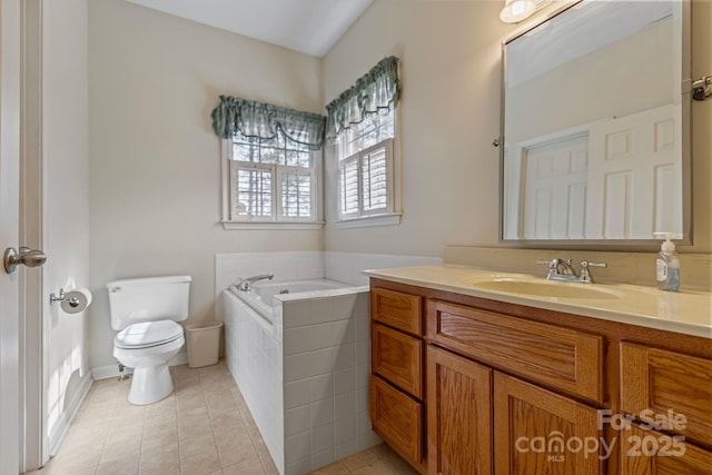 bathroom featuring tile patterned floors, vanity, toilet, and tiled tub