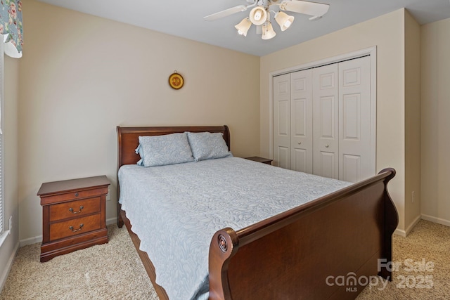 bedroom with a closet, ceiling fan, and light colored carpet