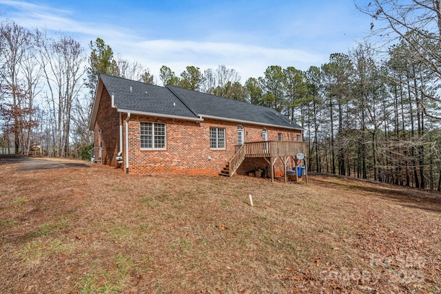 rear view of property featuring a yard and a wooden deck