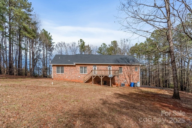 back of house featuring a deck and a lawn