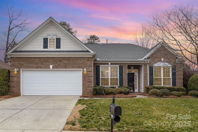 view of front of property featuring brick siding, roof with shingles, concrete driveway, a front yard, and a garage