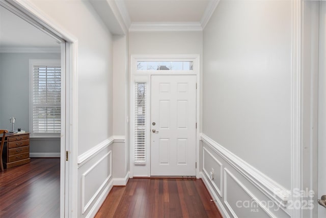 foyer entrance with dark wood-style floors, a decorative wall, crown molding, and a wainscoted wall