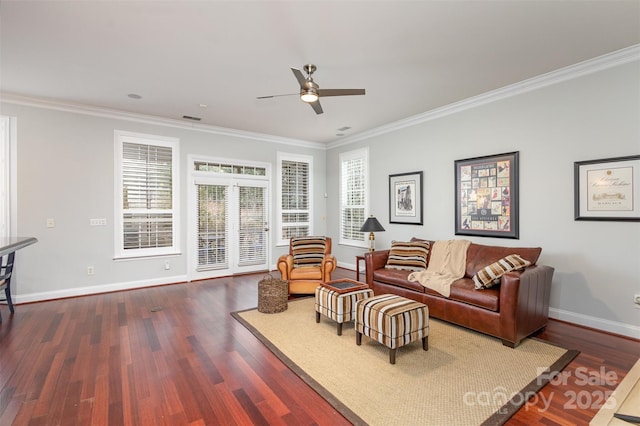 living area featuring a healthy amount of sunlight, crown molding, and dark wood-type flooring