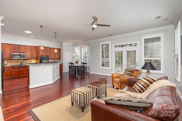 living room with baseboards, dark wood-type flooring, a ceiling fan, and crown molding