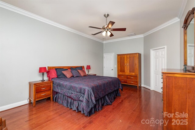 bedroom featuring visible vents, dark wood finished floors, baseboards, ceiling fan, and ornamental molding