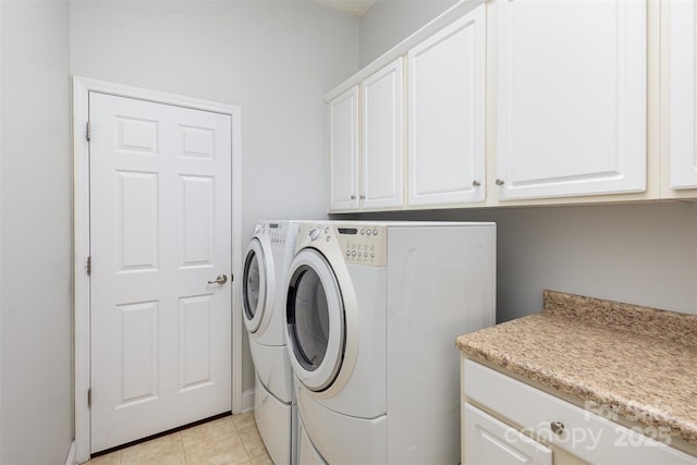 laundry area with cabinet space, independent washer and dryer, and light tile patterned flooring