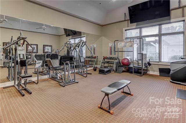 workout area featuring carpet floors, a ceiling fan, and baseboards