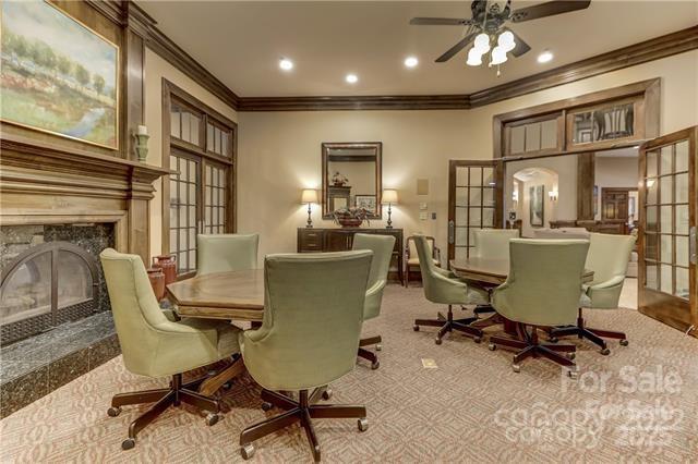 living area with light colored carpet, a high end fireplace, ornamental molding, and french doors