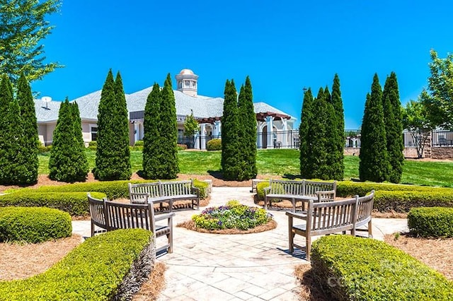 view of property's community with fence and a patio