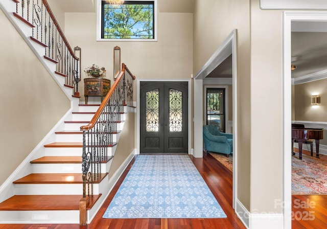 entryway featuring a high ceiling, french doors, and hardwood / wood-style flooring