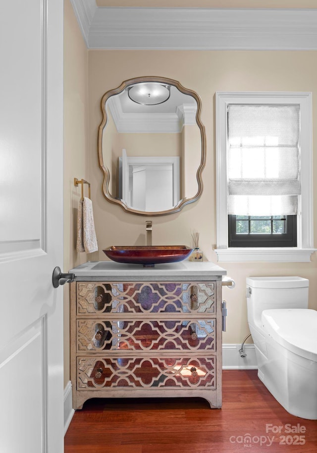 bathroom with toilet, hardwood / wood-style flooring, crown molding, and vanity