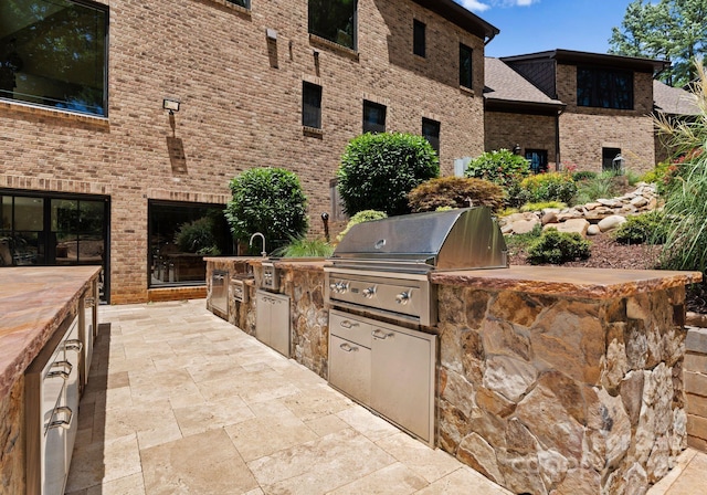 view of patio featuring grilling area, exterior kitchen, and sink