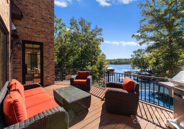 wooden deck with a water view and an outdoor hangout area